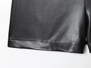 Détail de l'ourlet à couture simple et texture fine du short en similicuir noir à taille haute