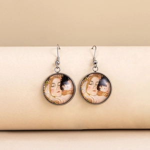 Macro detail of hook earrings with artistic female portrait under glass dome