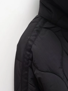 Detail of shoulder stitching and decorative webbing on black quilted winter jacket