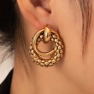 Chic gold-plated nested hoop earrings with beaded texture on model, modern style