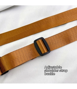 Close-up of adjustable brown woven shoulder strap with black buckle for versatile length