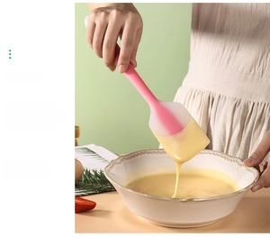 Pink silicone spatula mixing batter in a bowl for DIY cake baking and smooth cream spreading