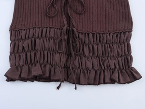 Detail of dark brown knitted top featuring ruffled texture and drawstring waist design
