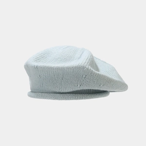 Detail of light blue knit beret showing fine texture and rolled edge design
