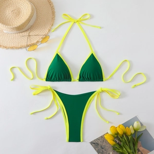 Close-up of dark green bikini with neon yellow trim and adjustable side tie details
