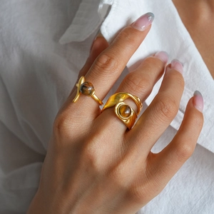 Close-up of golden tiger eye stone rings with textured double-layer wrap design