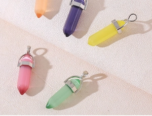 Macro shot of colorful hexagonal crystal prism pendants with silver metal clasps