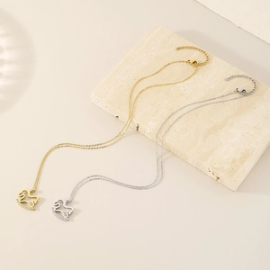 Cute gold and silver rocking horse necklaces with rhinestones on stone background