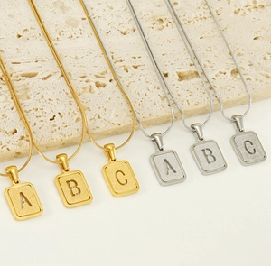 Détail de pendentifs rectangulaires en or 18K et argent sur chaînes serpent