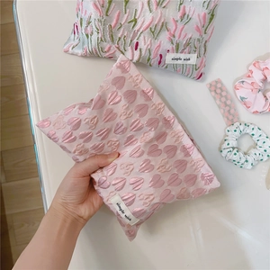 Close-up of pink heart jacquard makeup bag with simple wish label and textured fabric