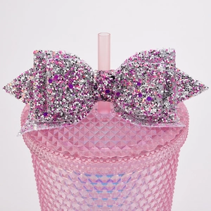 Detail of silver and pink glitter bow decoration on a textured pink diamond tumbler