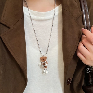 Close-up of a brown flocked bear pendant with white teardrop pearls and silver ball chain
