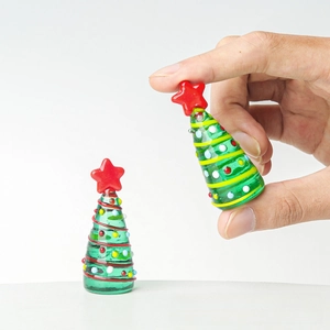 Macro view of handmade glass mini Christmas trees with colorful dots and red star