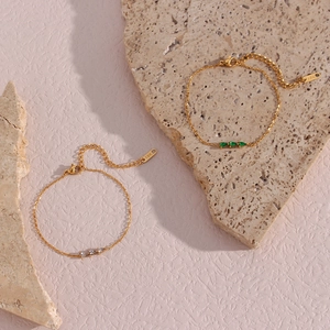 Close-up of 18K gold O-chains with pear-cut green gems and zircon detailing