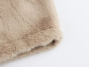 Détail de la texture en fausse fourrure douce et coutures précises sur la veste marron