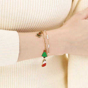 Detail of Christmas themed layered bracelet set with festive charms on a knit sleeve