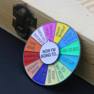 Detail of a rotating rainbow enamel mood pin showing decision wheel with twelve colors