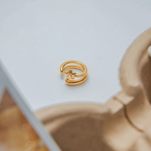Vue macro d'une bague étoile dorée à double couche avec un détail de pierre sertie