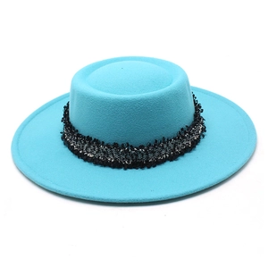 Detalle del sombrero de fieltro de lana azul cielo con cinta de flecos negros