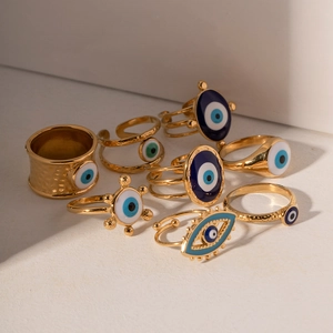 Vintage gold evil eye ring collection with blue enamel charms and hammered metal texture
