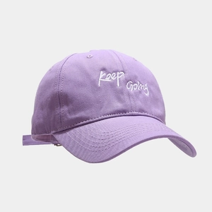 Close-up of the Keep Going white embroidery on a light purple cotton baseball cap