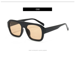 Detail view of large square black frame sunglasses with light orange tinted lenses