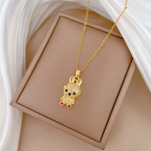 Detail of a gold bunny necklace pendant with sparkling crystals and red gemstone eyes