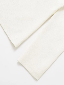 Close-up of white knitted texture and fine ribbed cuffs on a stylish women cardigan