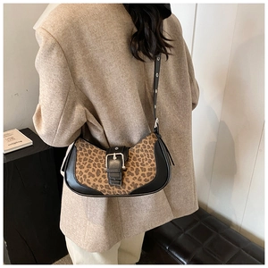 Vue détaillée du sac sous le bras en léopard avec cuir noir et boucle sur un modèle
