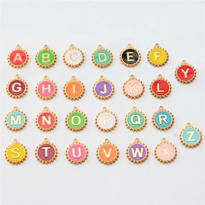 Macro shot of 26 colorful enamel alphabet charms with gold plating and diverse vibrant hues