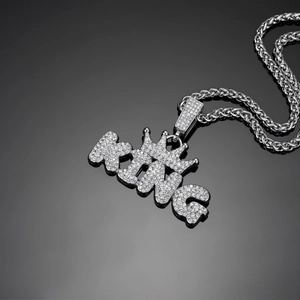 Macro shot of silver-plated hip hop King crown pendant with iced out rhinestones