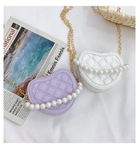 Detail of heart-shaped quilted bags with pearl handles in lavender and white colors