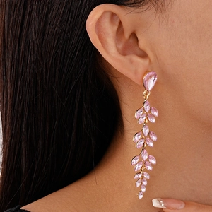 Detail of elegant leaf drop earrings with pink crystals on model for a graceful look