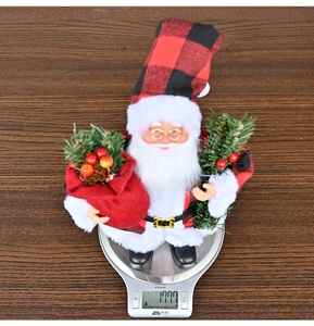 Detail of Christmas Santa figurine in plaid hat being weighed on a digital scale