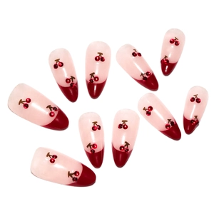 Short almond press-on nails with red French tips and 3D cherry accents on nude base