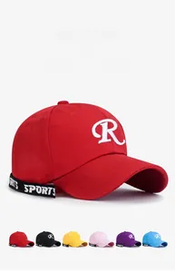 Detail of red cotton baseball cap featuring 3D embroidered R and colorful ribbon accents