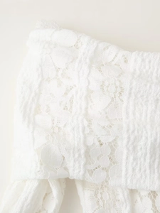 Gros plan sur un élégant tissu en dentelle blanche aux motifs floraux et texture mesh