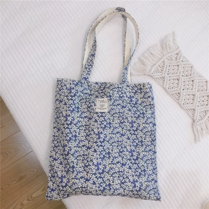 Flat lay of a floral cotton tote bag with daisy patterns on white quilted fabric