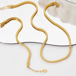 Minimalist gold snake chain necklace set with two layered polished steel chains on water droplets