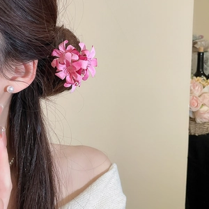 Detailed close-up of an elegant pink fabric flower hairpin worn in a delicate hair bun