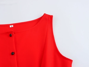 Detail view of red sleeveless chiffon top with black buttons and white size S label