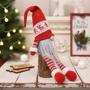 Christmas gnome dolls with red reindeer knit hats on a cozy wooden table background