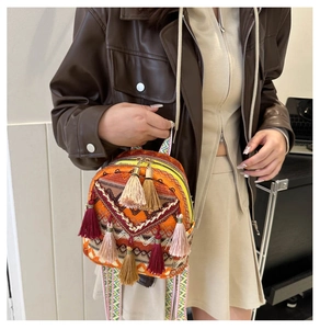 Detailed view of bohemian mini backpack featuring vibrant embroidery and colorful tassels