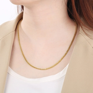 Golden stainless steel dragon bone chain necklace worn by a model in a professional close-up