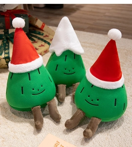 Close-up of three cute plush Christmas trees with festive hats on a cozy background