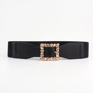 Close-up of black elastic waist belt with gold square buckle and rhinestone leaves