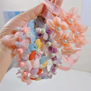 Detail of baby elastic headbands with mesh flowers and pearls in multiple colors