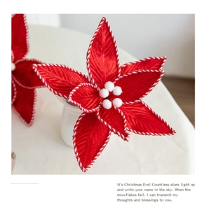 Detailansicht einer luxuriösen roten Samt-Weihnachtsblume mit weißen Ziernähten.