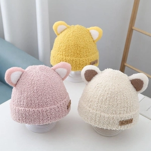 Plush baby earflap hats in yellow, pink, and beige with cute animal ear designs