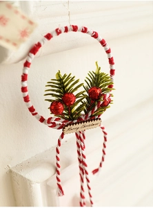 Close-up of a Christmas wreath with pine needles, red berries, and a Merry Christmas tag